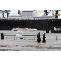 2967_1403-21 Helfer waten durch das Wasser des überfluteten Fischmarktgeländes. | Hochwasser in Hamburg - Sturmflut.